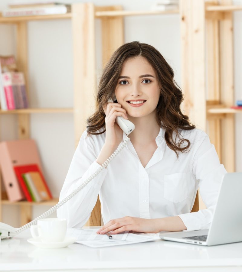 young-woman-talking-on-phone-in-modern-office.jpg